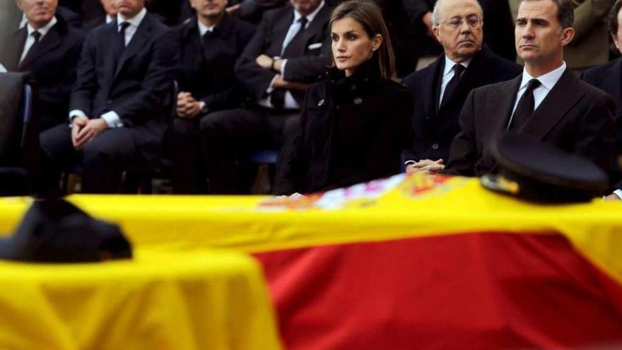 Los Reyes, ayer en Madrid, presiden el funeral por los dos policías asesinados en Afganistán. // Reuters