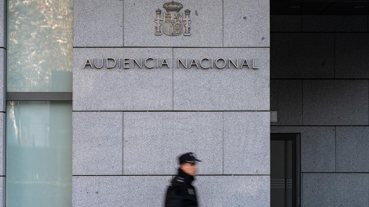 Archivo - Un agente de Policía Nacional camina frente a la Audiencia Nacional