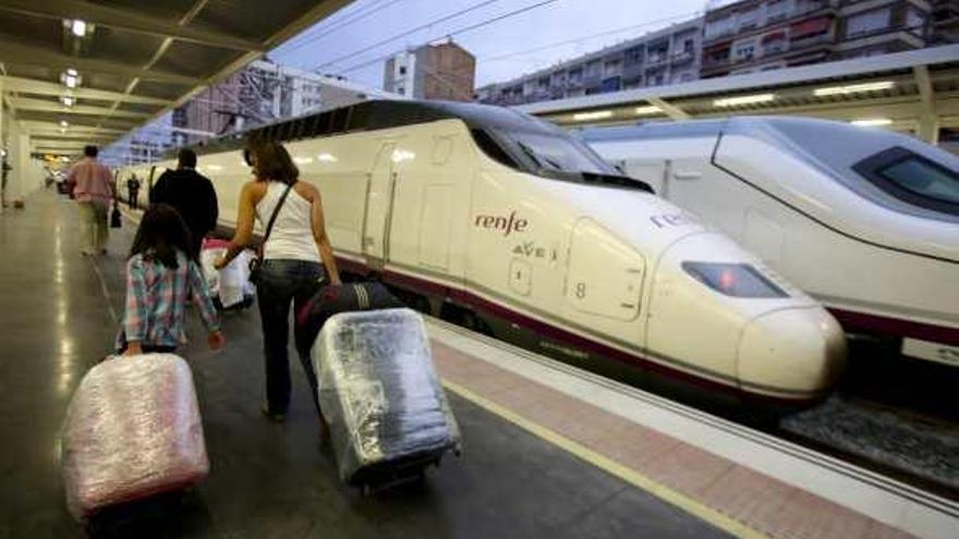 Viajeros en la estación del AVE de Alicante, junto a los trenes de alta velocidad.