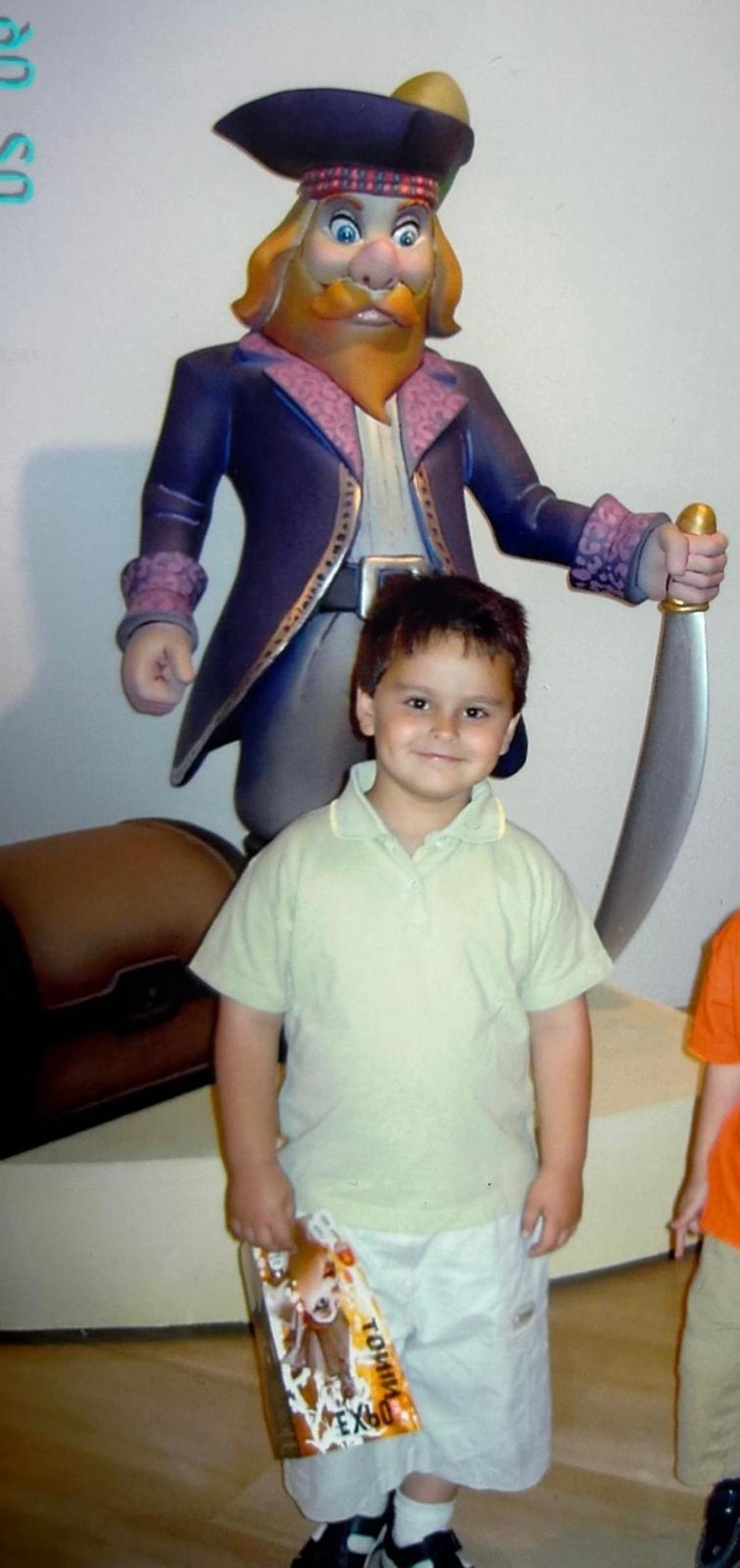 Adrián Gomis "Funzo" de niño ante un ninot de las Hogueras