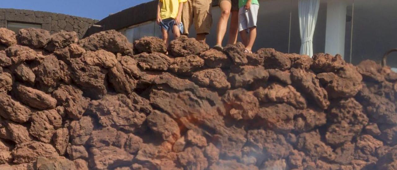 Turistas observan en Lanzarote el calor que desprende el suelo volcánico. |