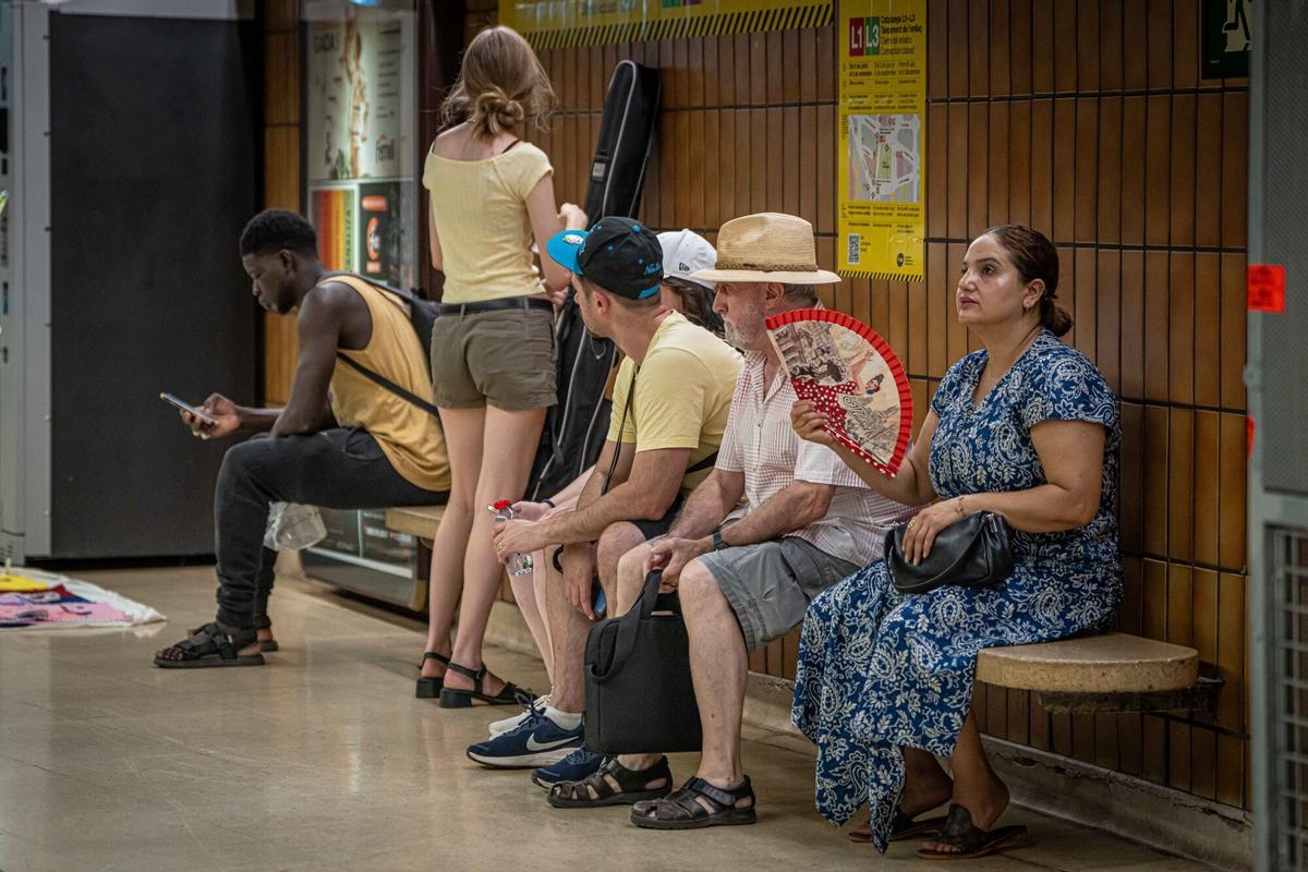 Calor en la estación de Plaza Catalunya de la L1 del metro de Barcelona. Viajeros esperan en los andenes soportando las altas temperaturas con abanicos, ventiladores portátiles y otros métodos para combatir el calor, pese a que la estación debía beneficiarse de las mejoras de ventilación anunciadas. A 30 de julio de 2026. Barcelona. AUTOR: MANU MITRU