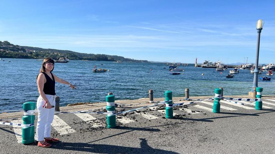 La concejala socialista Iria Malvido muestra los daños en el muelle de Aldán