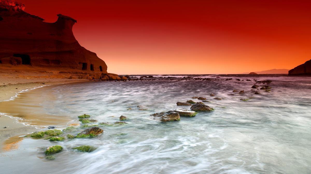 La playa murciana de los Cocedores, en el entorno que rodea a la denominada Cala Cerrada, es un espectacular paraje en el que el cielo parece teñirse de rojo, naranja o rosa, según la etapa del año.