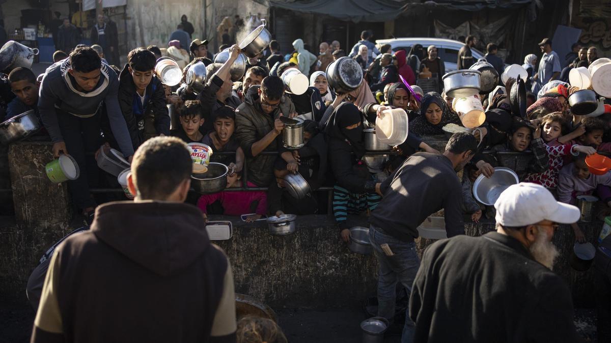 Gazatíes hacen cola para recibir comida en la ciudad de Rafah, este martes.