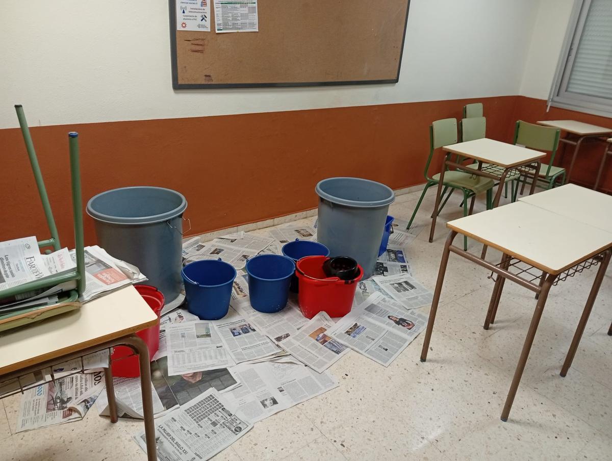 Cubos para contener las goteras en un aula.