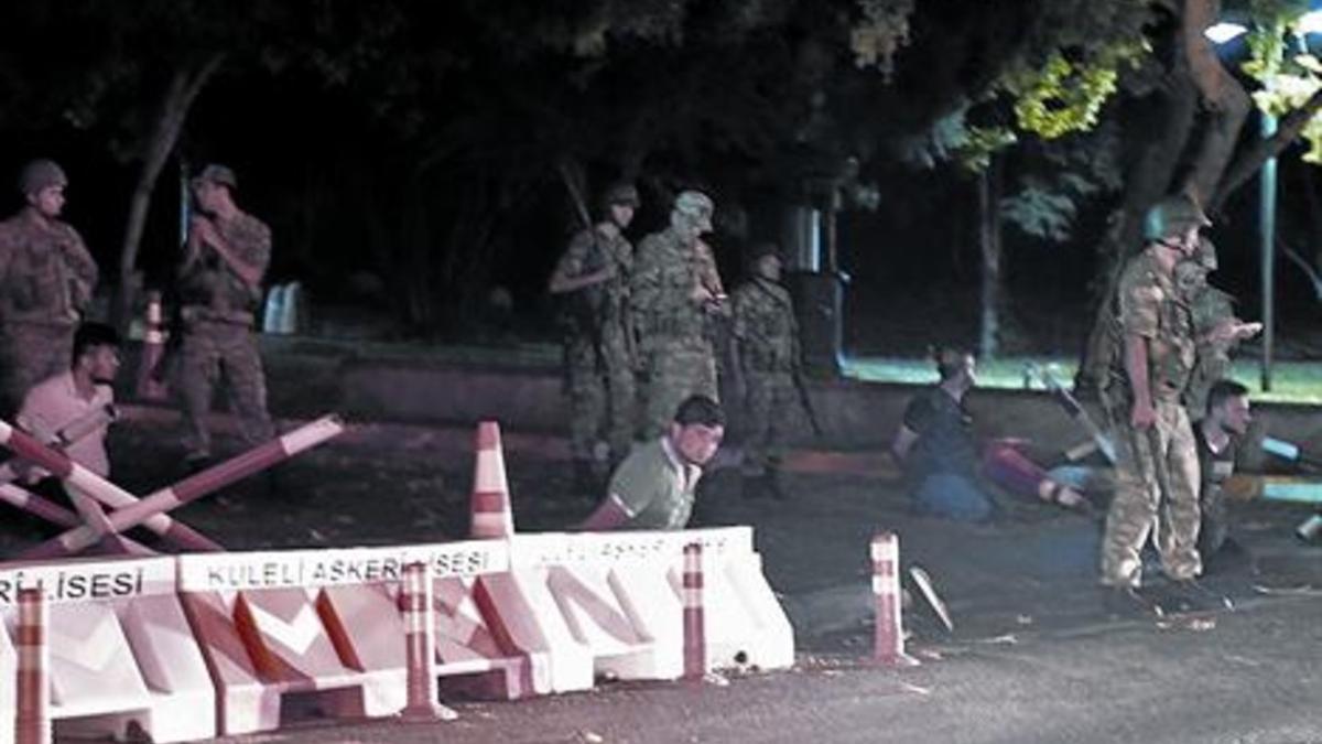 Militares turcos retienen a civiles arrodillados bajo el puente del Bósforo en Estambul, anoche.