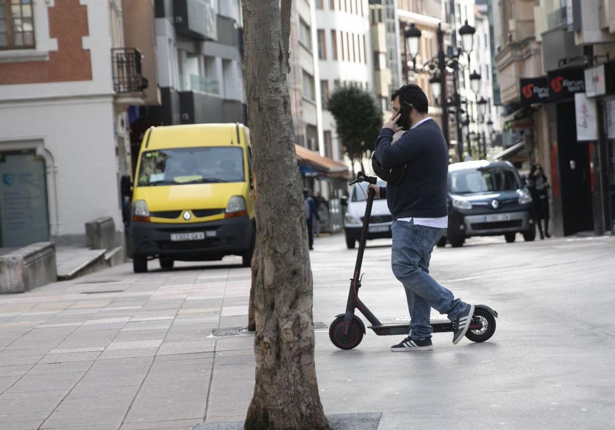 Un usuario con un patinete eléctrico en el centro de Oviedo. | Irma Collín