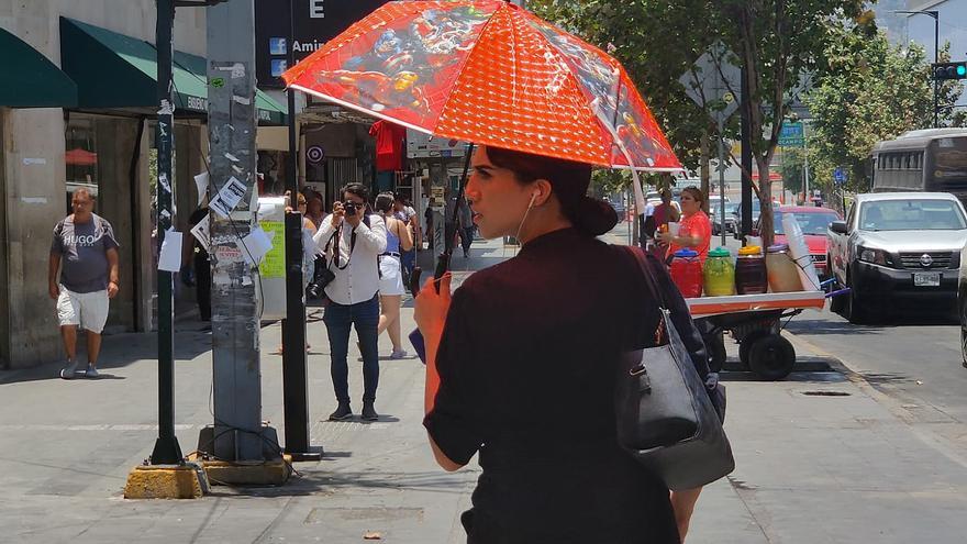 Una mujer se protege del calor en Nuevo León.