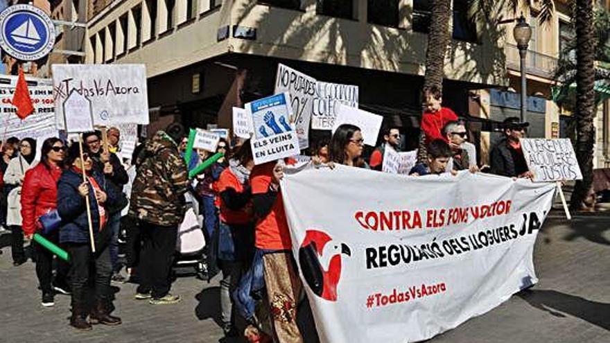 Manifestants caminen pels carrers de Badalona amb una pancarta en contra del fons Azora