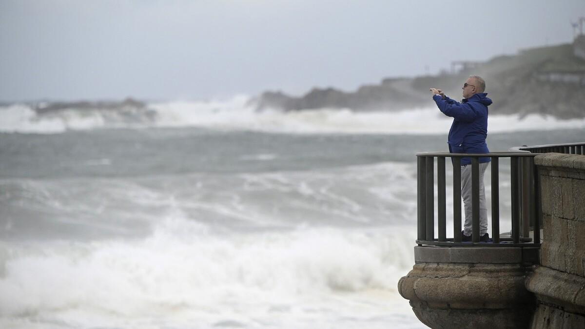 Un hombre toma una fotografía en la playa de Riazor, en A Coruña