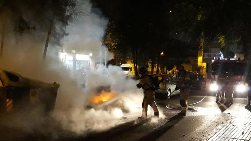 Bomberos apagan el fuego de los contenedores.