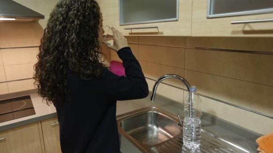 Una joven bebe agua directamente del grifo.