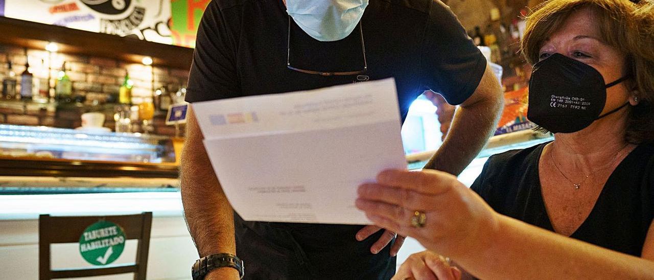 Una mujer muestra su Certificado Covid en un restaurante. | | EFE