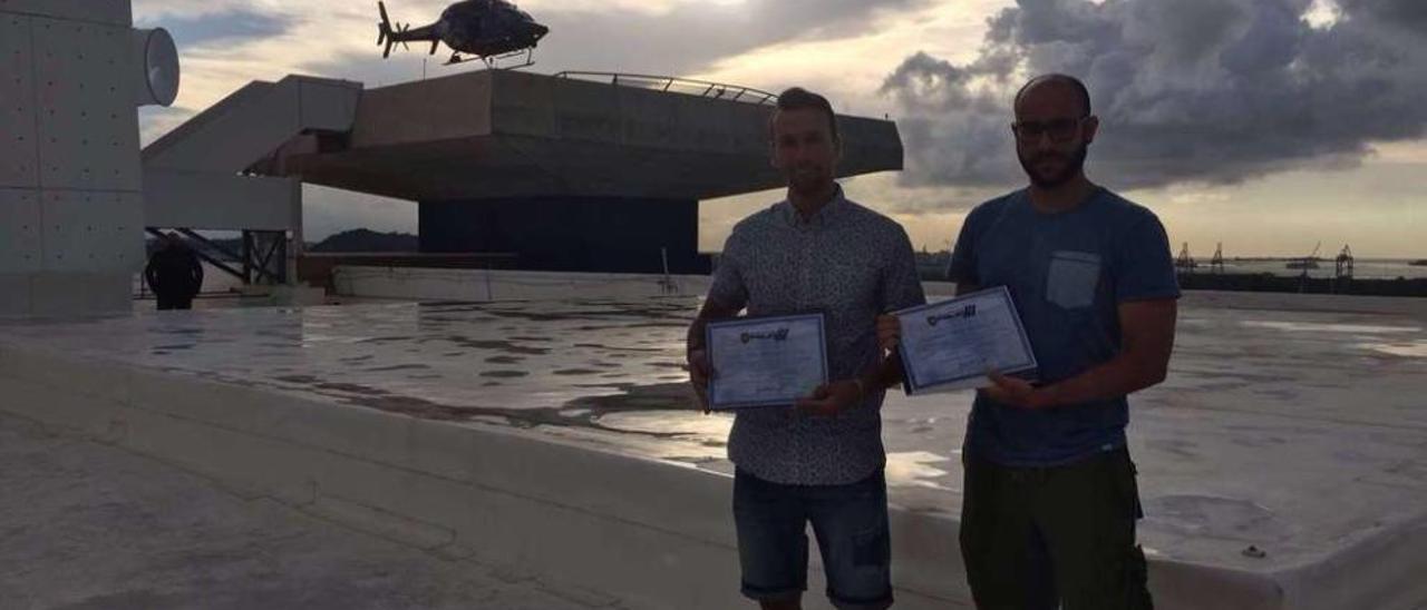 Pablo Galego (derecha) y su compañero Félix García posan en San Juan con sus diplomas de Bomberos Honorarios de Puerto Rico.