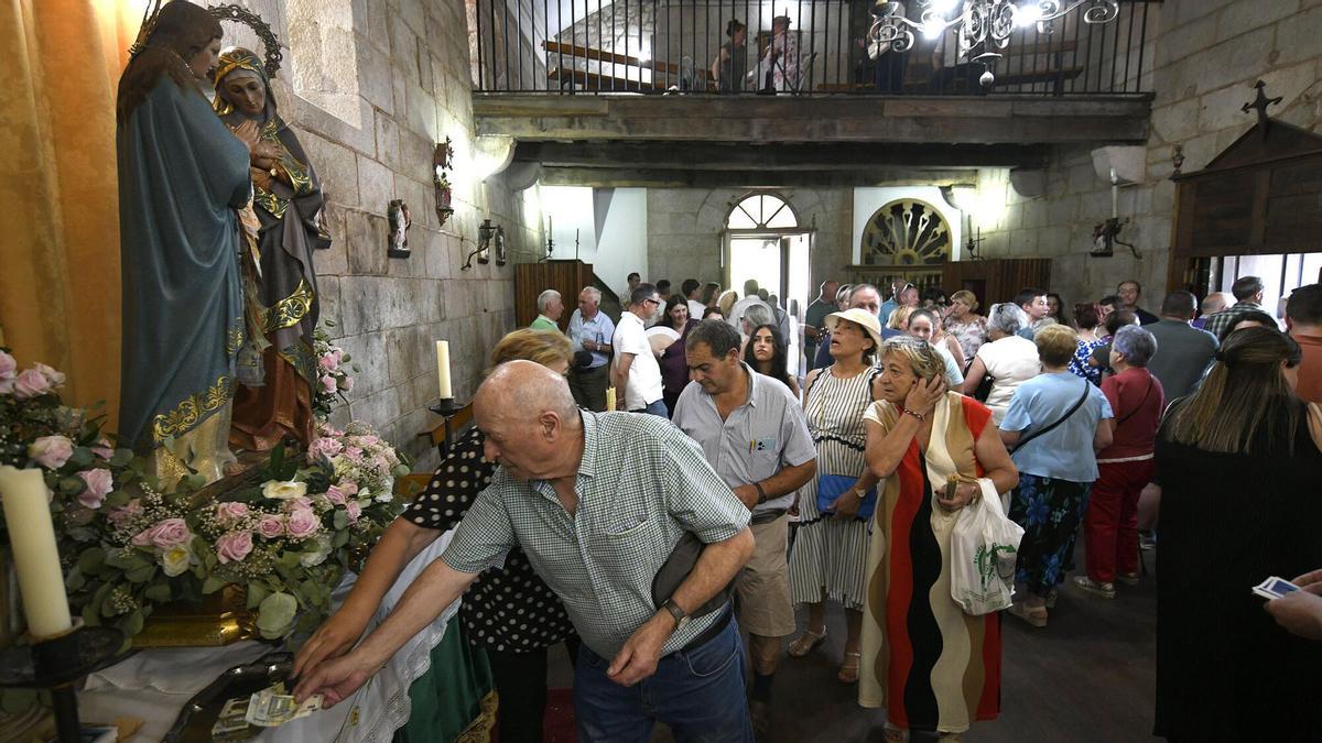 Devotos depositan ofrendas ante las imágenes de las santas.