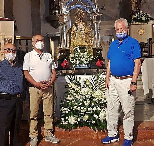 Vicente y Ceferino Cuadra, junto a Fernando Naredo, con la Virgen. A la derecha, Ernesto Seijas y Carmina Alonso, con su nieta Rita. | V. A.