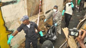 Personal de los servicios de rescate desalojan un cadáver del lugar del siniestro, en Monrovia. 