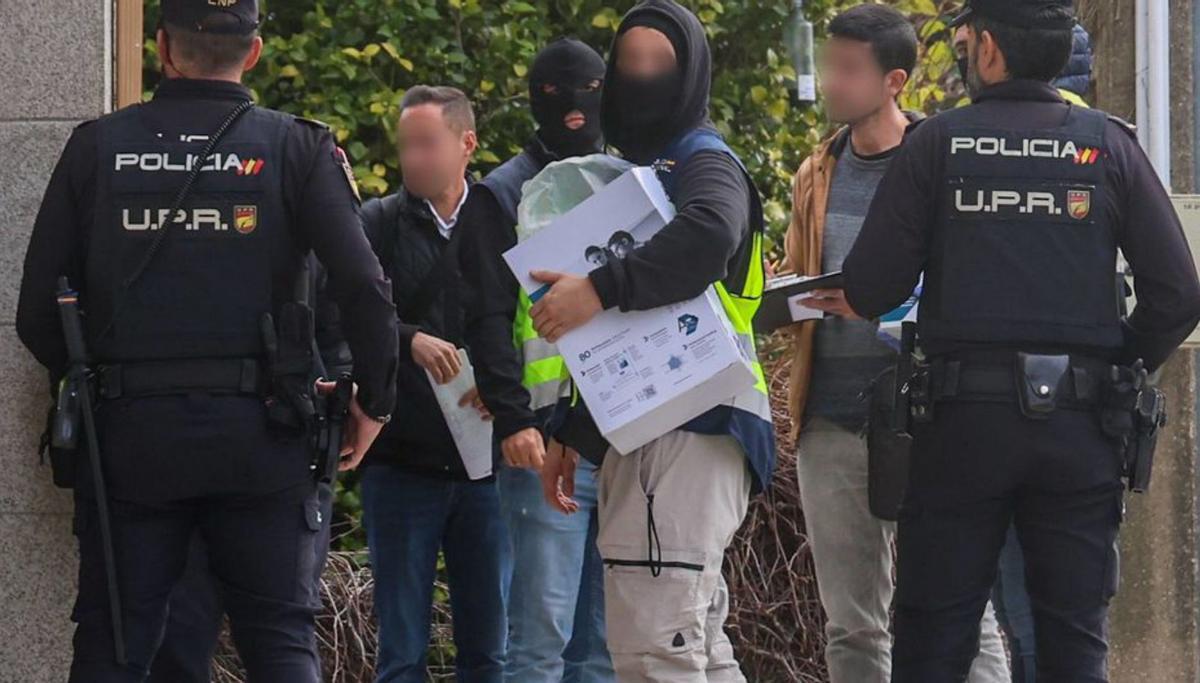 Agentes de la Policía Nacional con
documentación, en Ribadumia. | Iñaki Abella