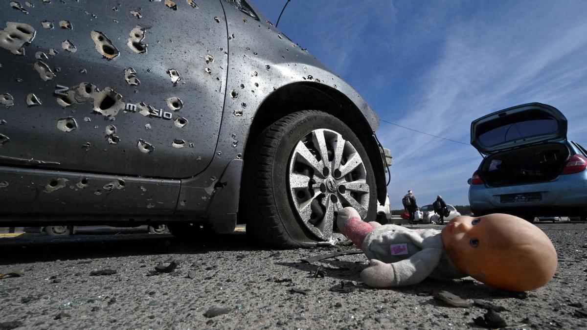 Una muñeca abandonada en el suelo junto a un vehículo agujereado por las balas durante la evacuación de civiles en la ciudad de Irpin, al norte de Kiev.