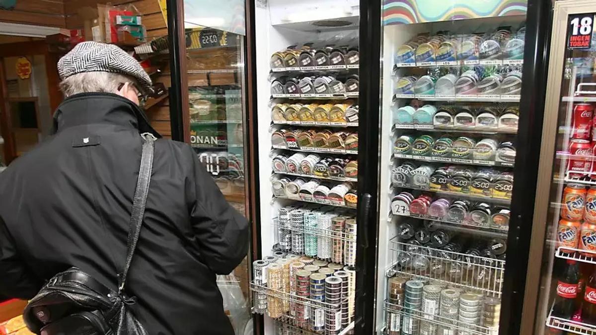 Un hombre examina latas de snus, la versión sueca del rapé oral, en la nevera de un quiosco de Estocolmo el miércoles 4 de marzo de 2009. Suecia está presionando a la Unión Europea para que levante la prohibición de la venta de snus en otros países de la UE.