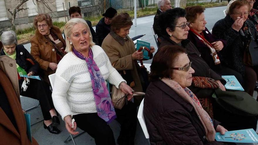 A la izquierda, Mila Garzo se dirige a los vecinos; a la derecha, Honorina Gil, en el centro, anima a sus amigas a cantar.