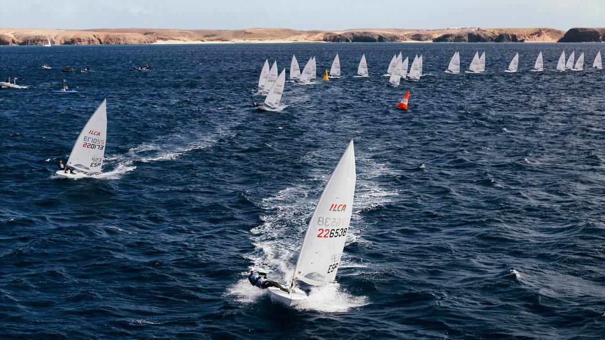 Flota de ILCA 6 regateando hoy con Lanzarote al fondo