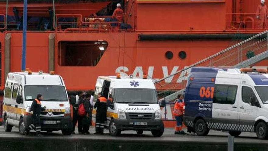 Los tripulantes rescatados, junto a las ambulancias que los esperaban en el puerto coruñés.