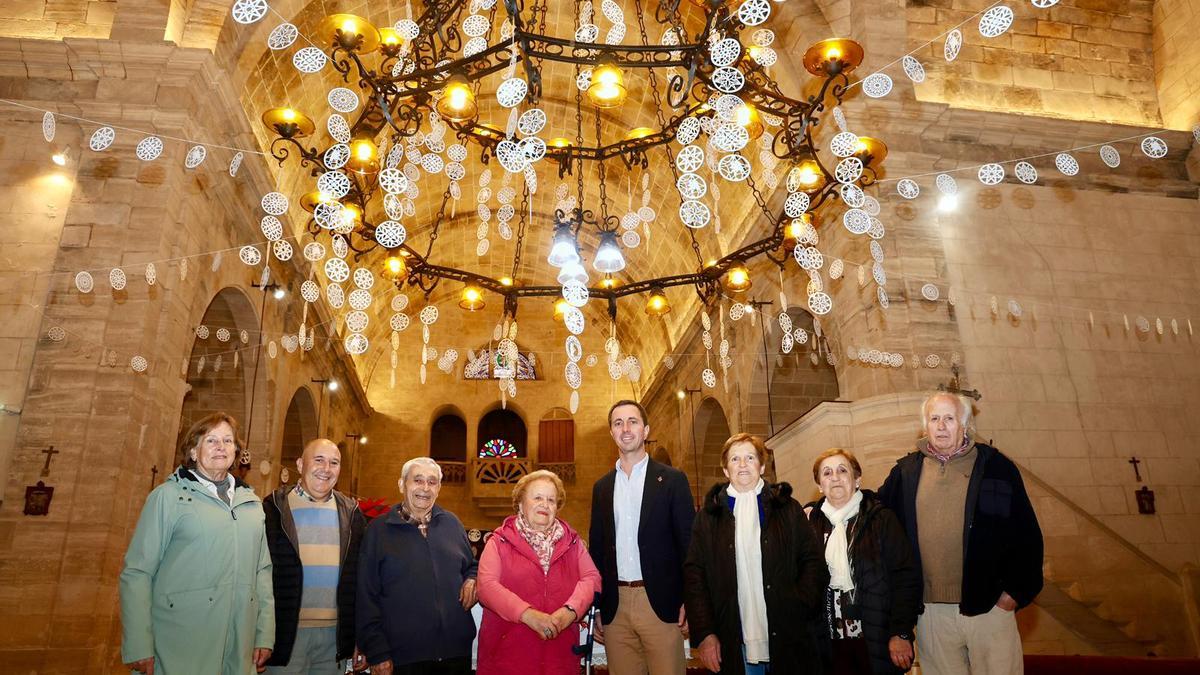 Maria Ribot, en el centro, junto al presidente Llorenç Galmés, junto a las 'neules' que decoran la iglesia de Ariany.