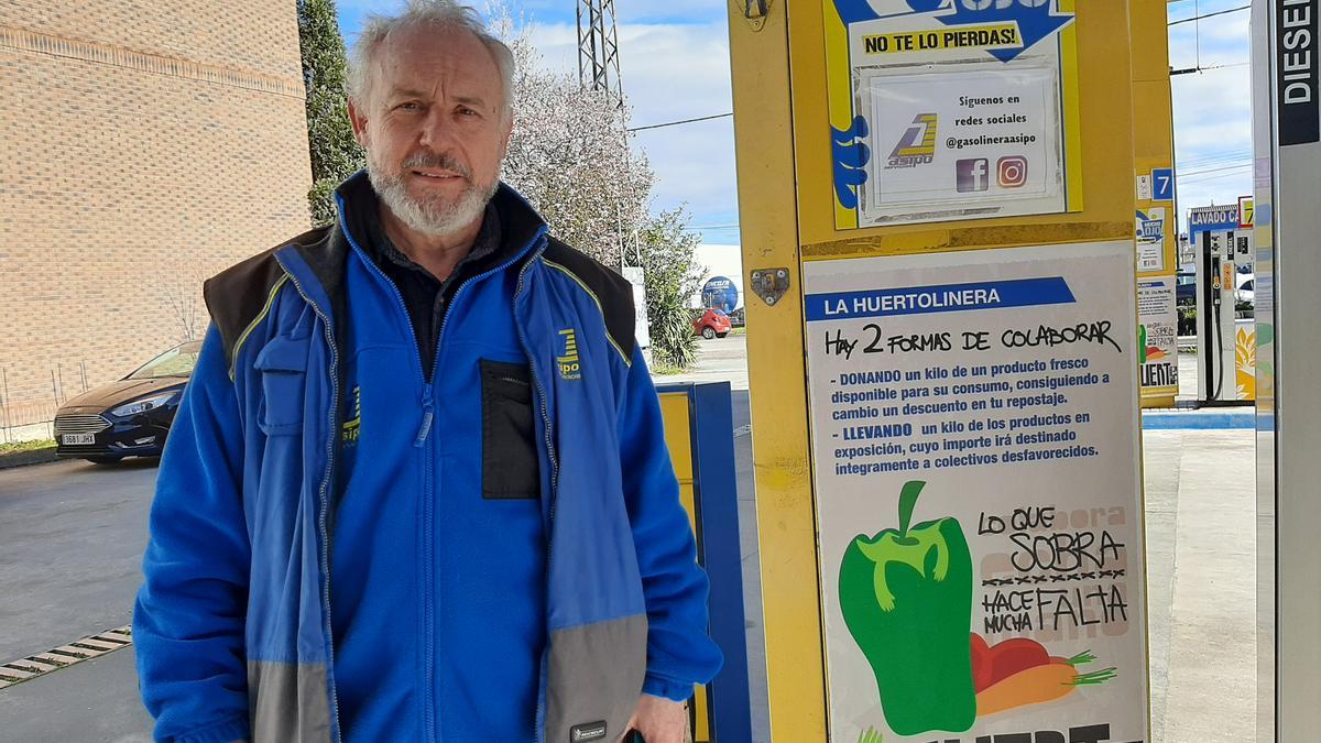 Fernando Villa, en su gasolinera, al lado del cartel que promociona "La Huertolinera"