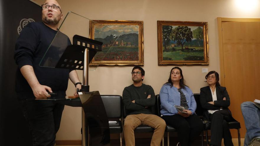 Juan Carlos Aparicio, en el atril, y sentados Rubén Domínguez junto a las restauradoras Alba Labrador e Isabel Mena durante la presentación, con las obras de Luis Bayón al fondo. | R. Solís