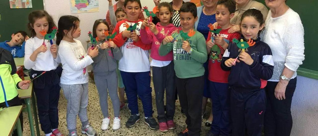 Las voluntarias del programa &quot;Rompiendo distancias&quot; muestran los marcapáginas con forma de gallo que elaboraron con los alumnos de 2.º curso del colegio Reconquista de Cangas de Onís.