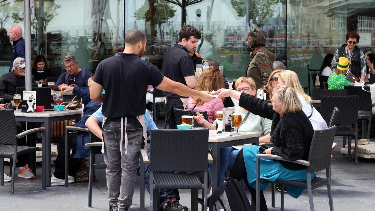 Camareros atendiendo mesas de la terraza de una cafetería en Vigo