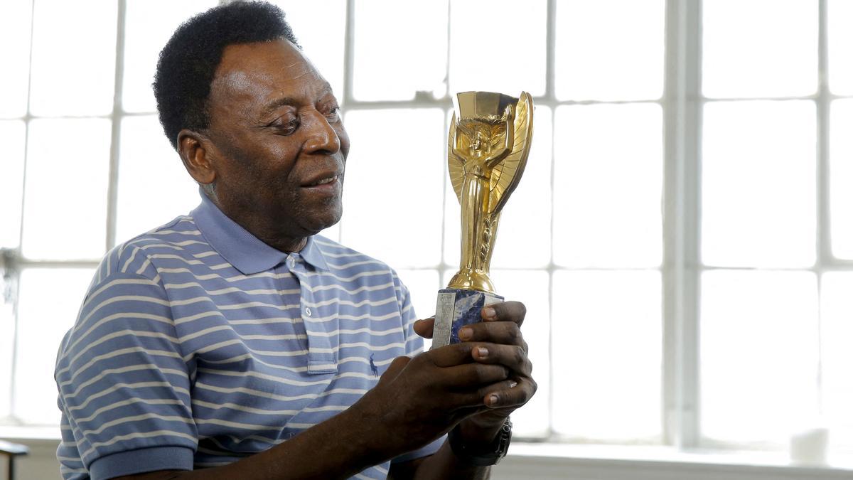 FILE PHOTO: Legendary Brazilian soccer player Pele poses for a portrait with his 1958 World Cup trophy during an interview in New York