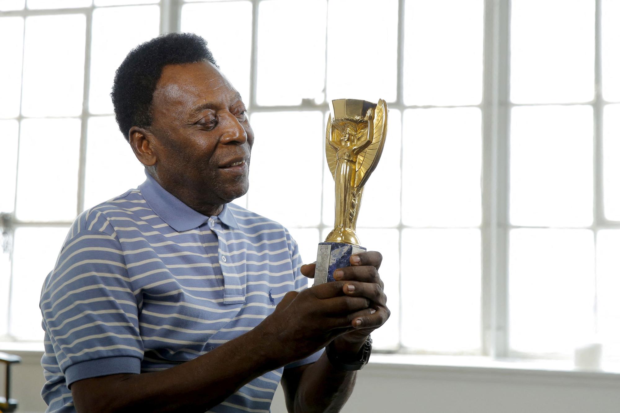 FILE PHOTO: Legendary Brazilian soccer player Pele poses for a portrait with his 1958 World Cup trophy during an interview in New York