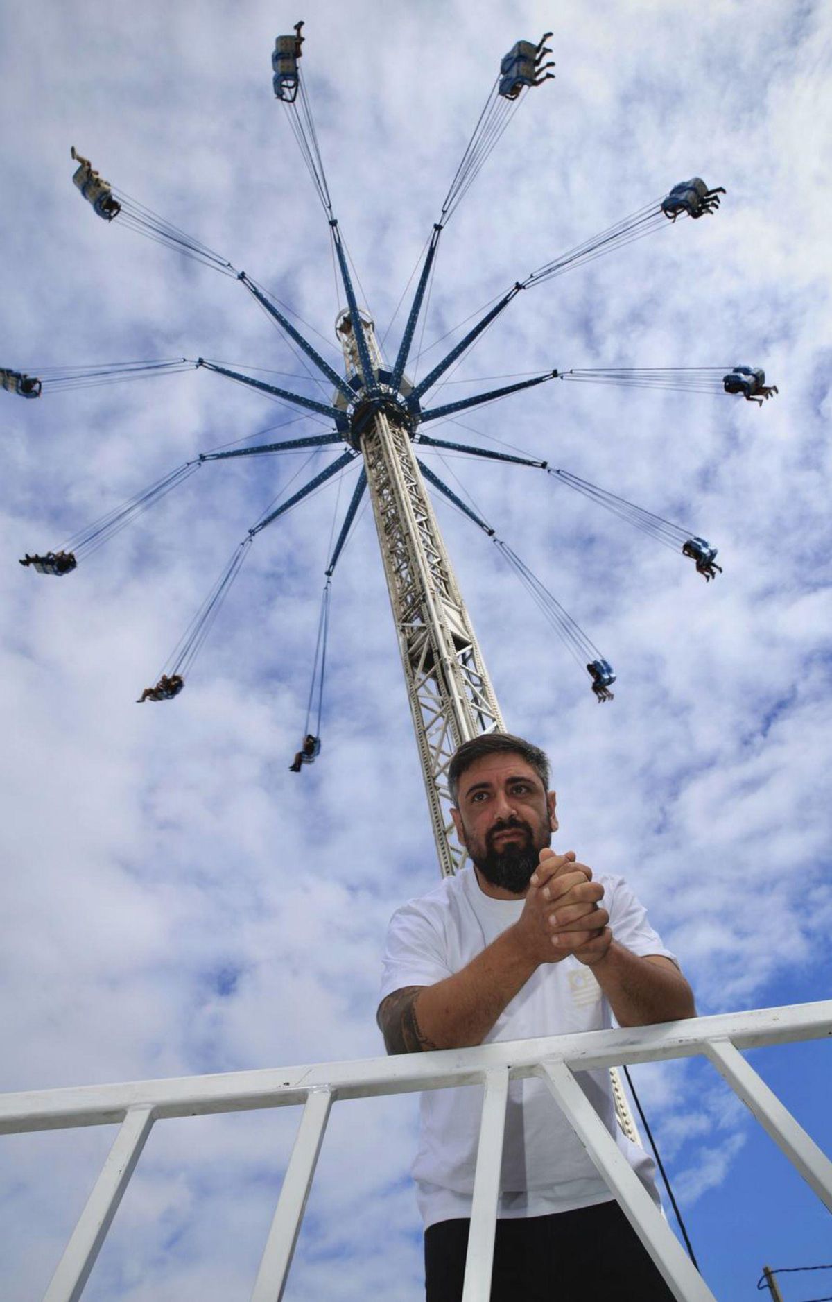 Edgar Araque, con su atracción de sillas voladoras al fondo.