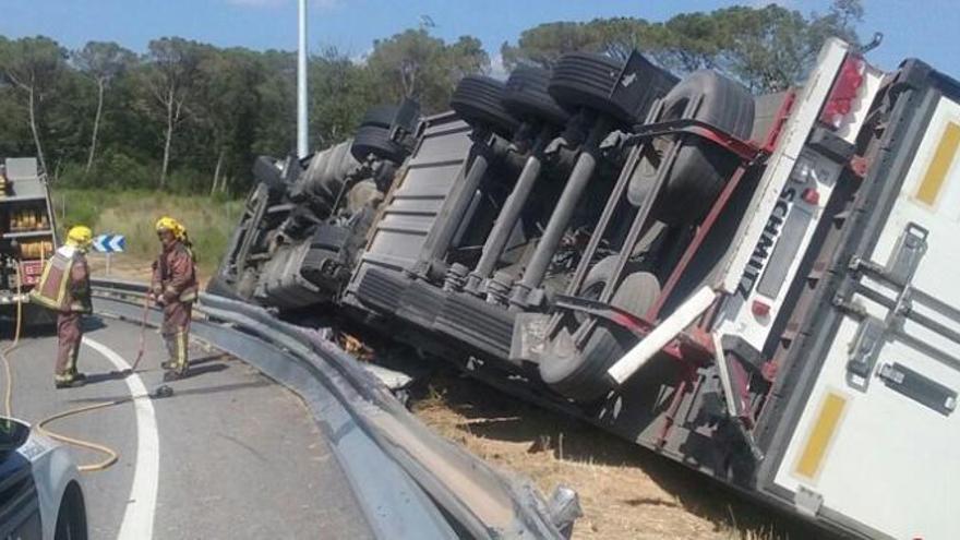 Els serveis d&#039;emergències treballant diumenge al punt on hi ha el camió bolcat