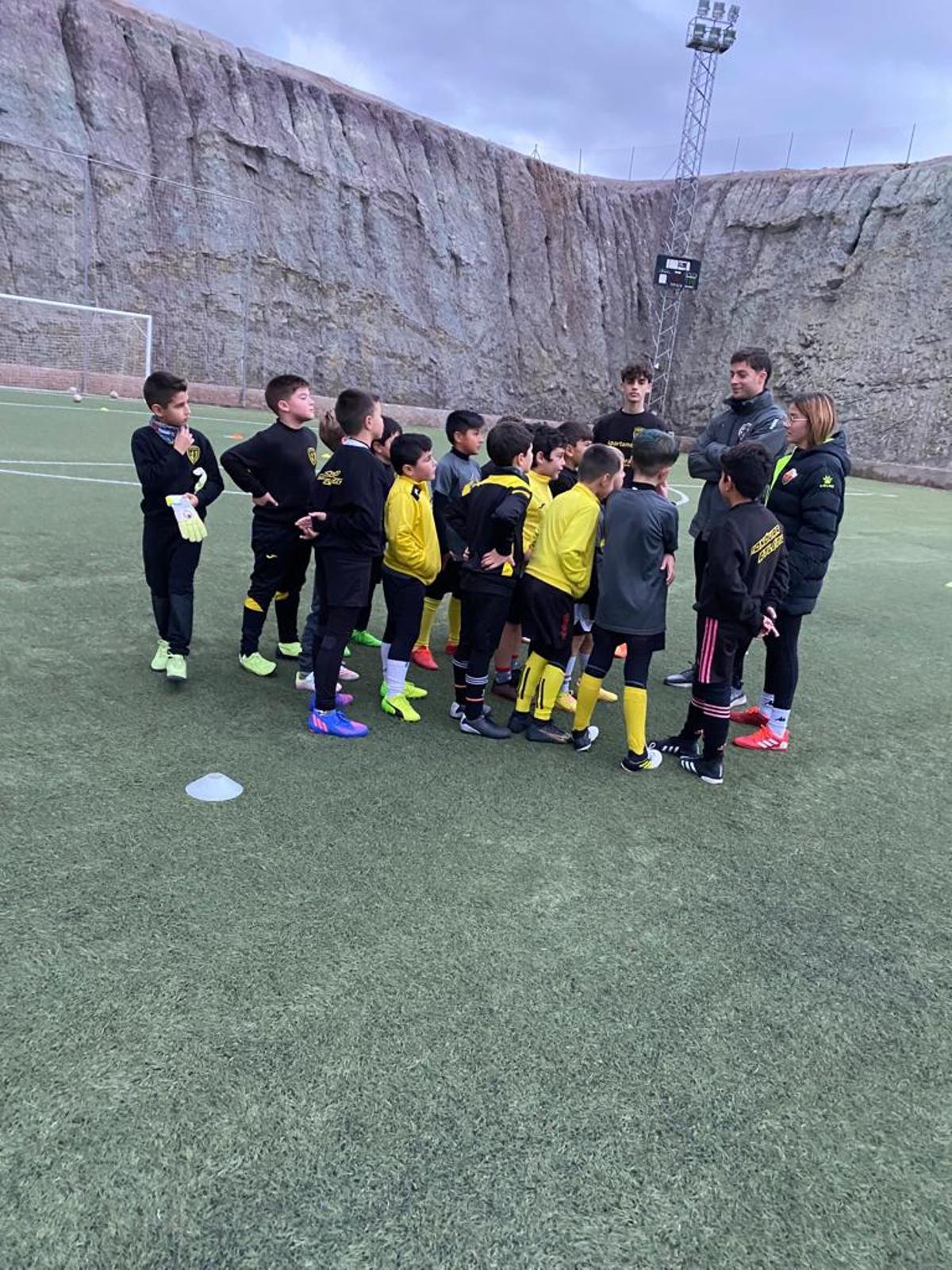 Los entrenadores del benjamín B hablando con los jugadores antes de iniciar el entrenamiento.