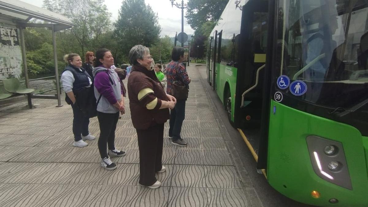 Viajeros cogiendo el autobús, este viernes, en Sama.