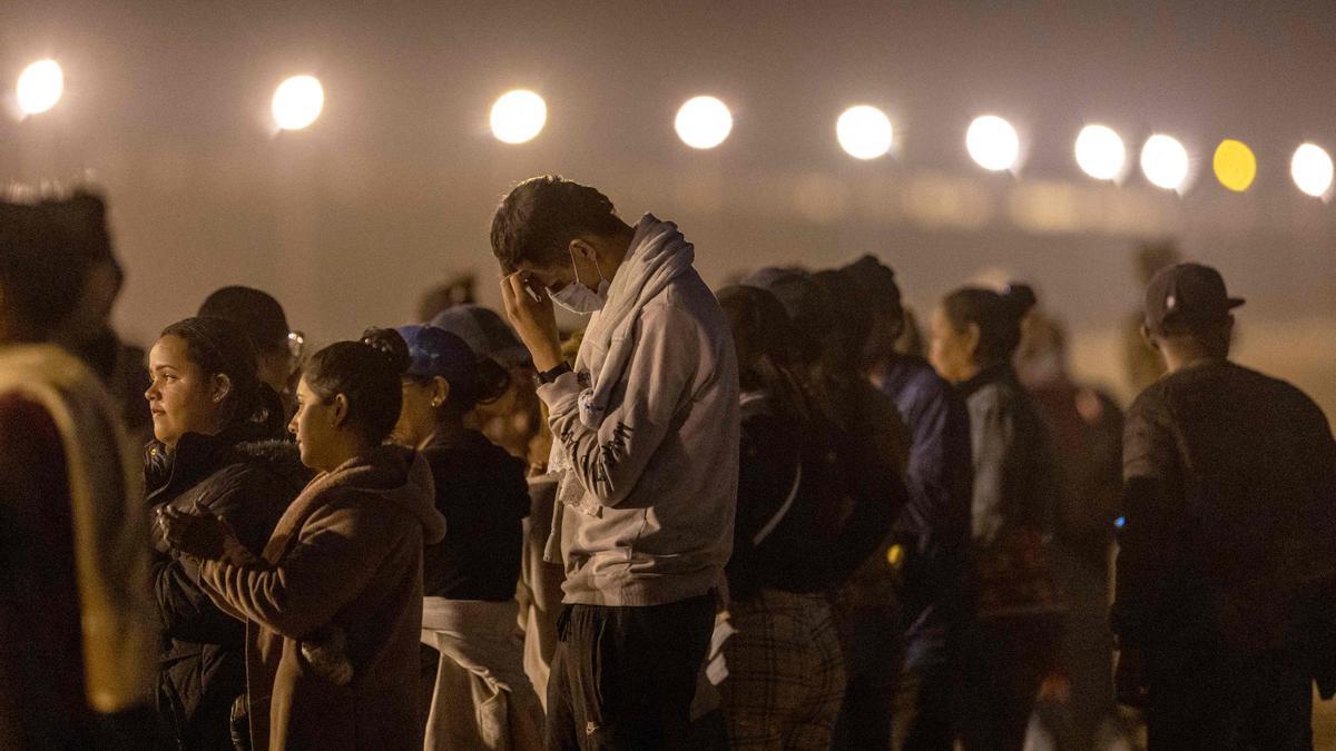 Migrantes en busca de asilo en EEUU esperan a ser procesados por agentes fronterizos tras cruzar desde México, este martes en El Paso (Texas).