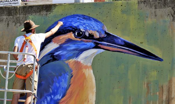 Swen Schmitz  pintando una de las aves que componen el mural de la EcoAula del Parc Fluvial del Besòs en Santa Coloma de Gramenet.