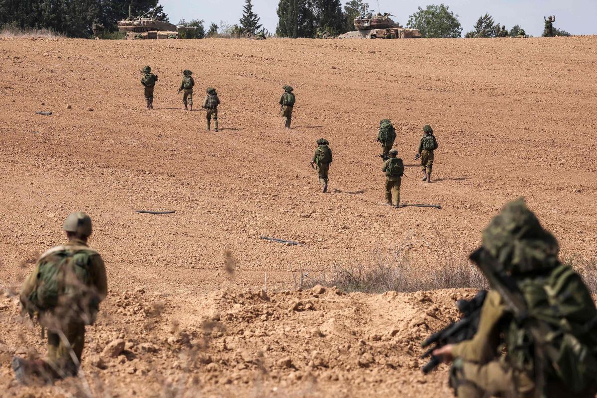 Soldados de Israel toman posiciones en Kfar Aza, al sur de Israel, en la frontera con la Franja de Gaza.