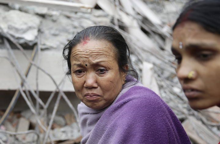 Nepalíes se reunen junto a los edificios derribados tras el terremoto