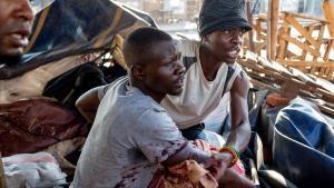 Un hombre ayuda a un herido a salir de una de las zonas conflictivas en el marco de las protestas por el resultado de los comicios en Zimbabue. 
