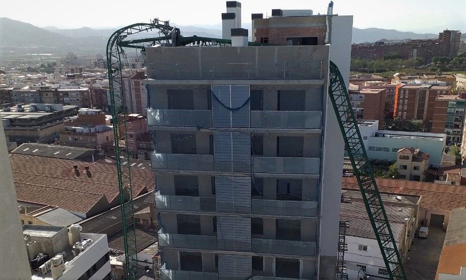 Una grua desplomada sobre un edificio de viviendas en Cornellà de Llobregat.