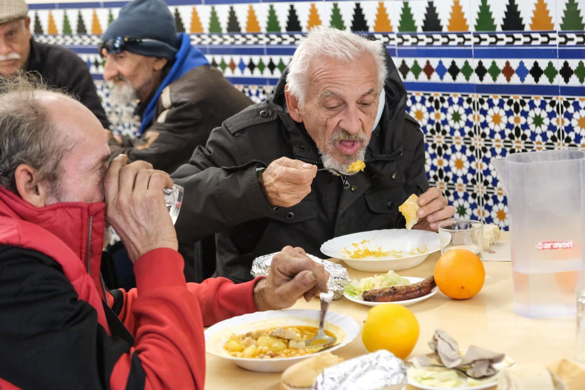 Un hombre come en el comedor social de Palmerales.