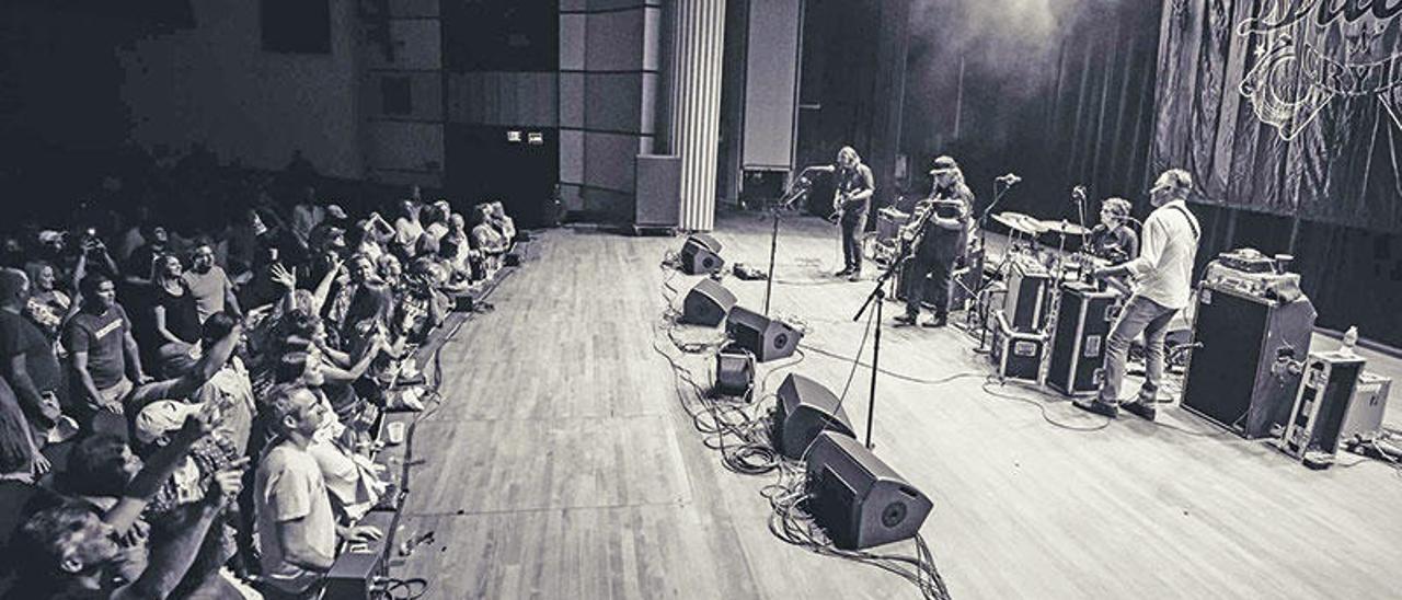 Imagen de un concierto de Drivin N Cryin con Kevn Kinney en el centro, con gorra.