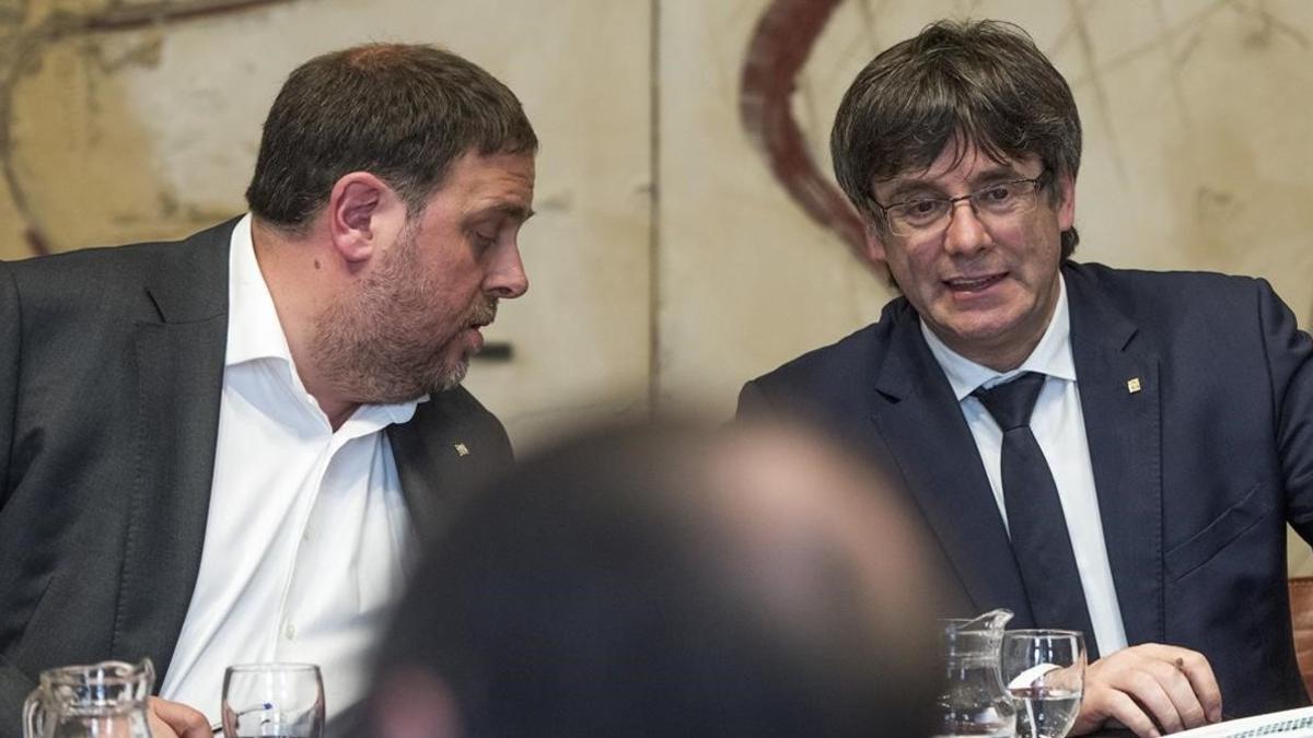 Oriol Junqueras habla con Carles Puigdemont, este martes, en la reunión del Consell Executiu.