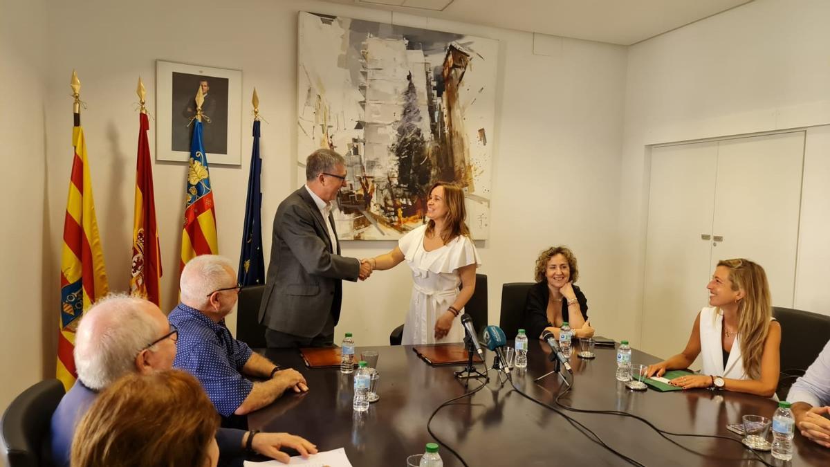 El conseller y la alcaldesa estrechan sus manos en el salón de plenos de Xixona tras la firma de la cesión