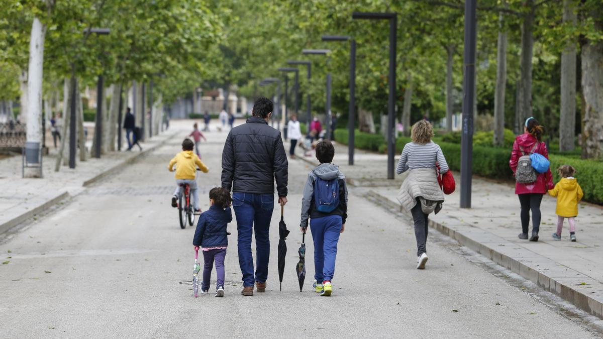 Varias personas pasean por un parque.